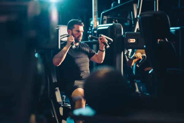 Member using Pulse Fitness chest press machine